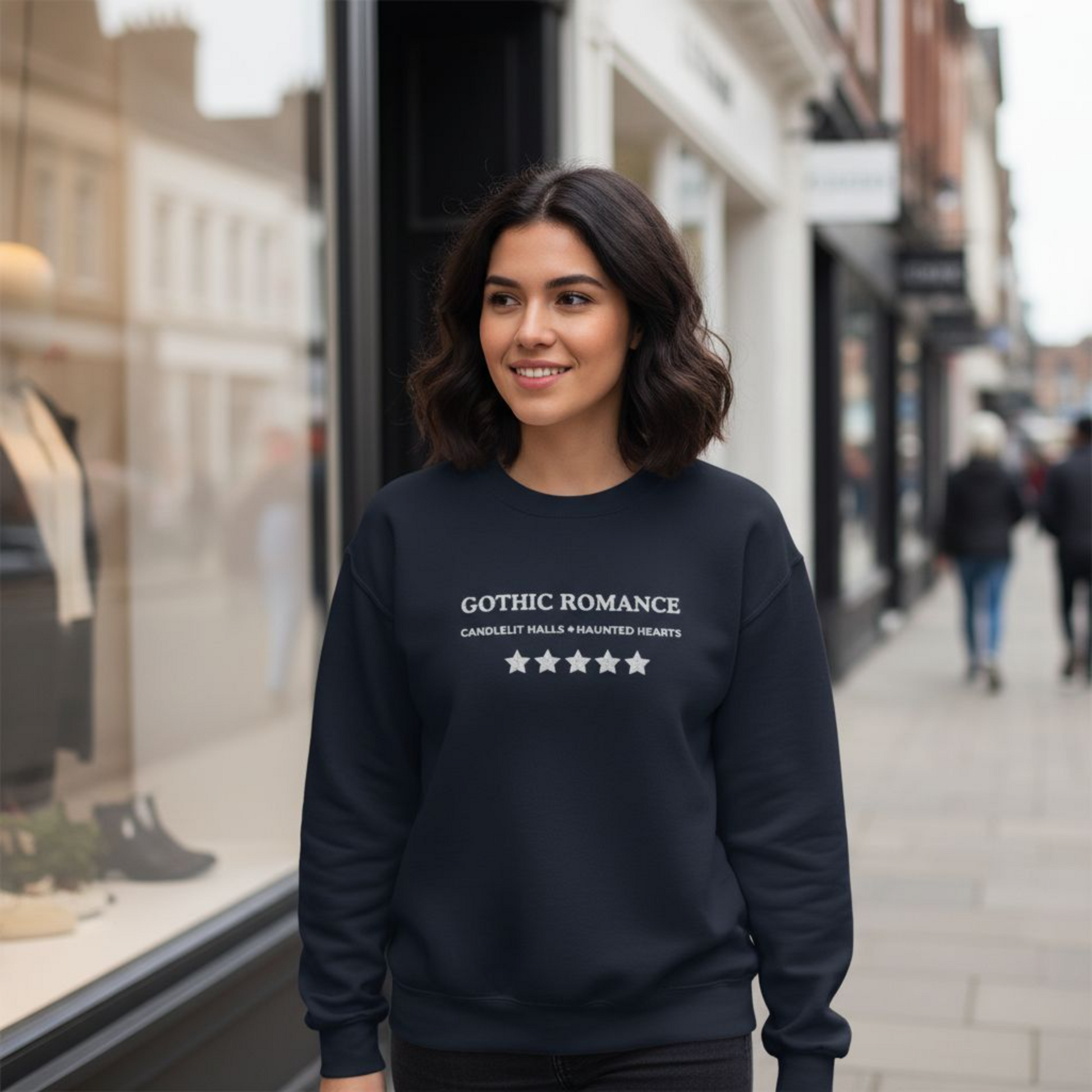 Woman wearing a black sweatshirt with 'Gothic Romance' text on a city street.